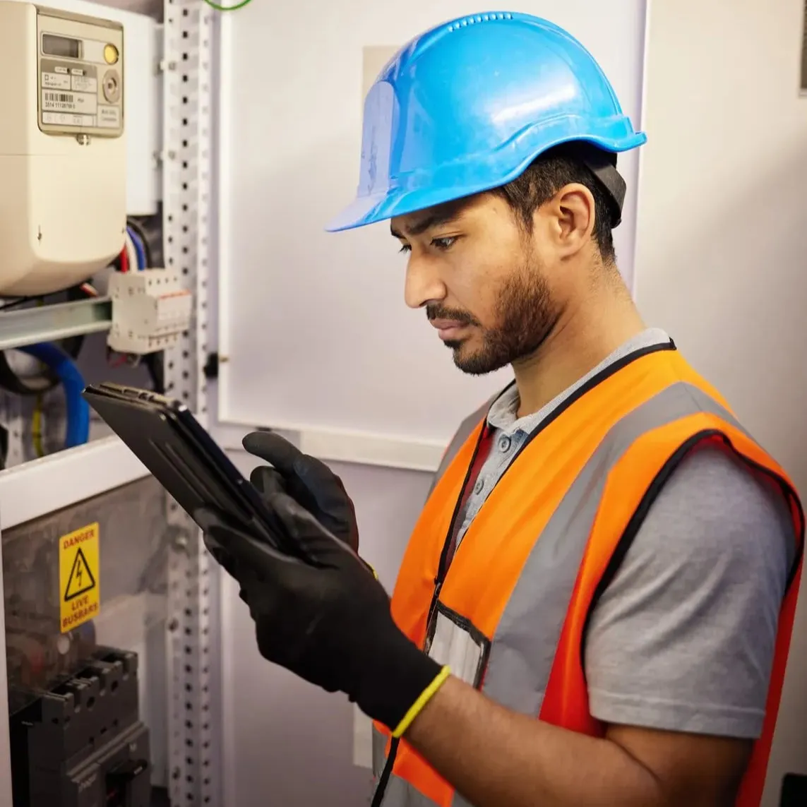 Ein Servicetechniker überprüft auf dem Tablet die Einstellungen des Schaltschranks.