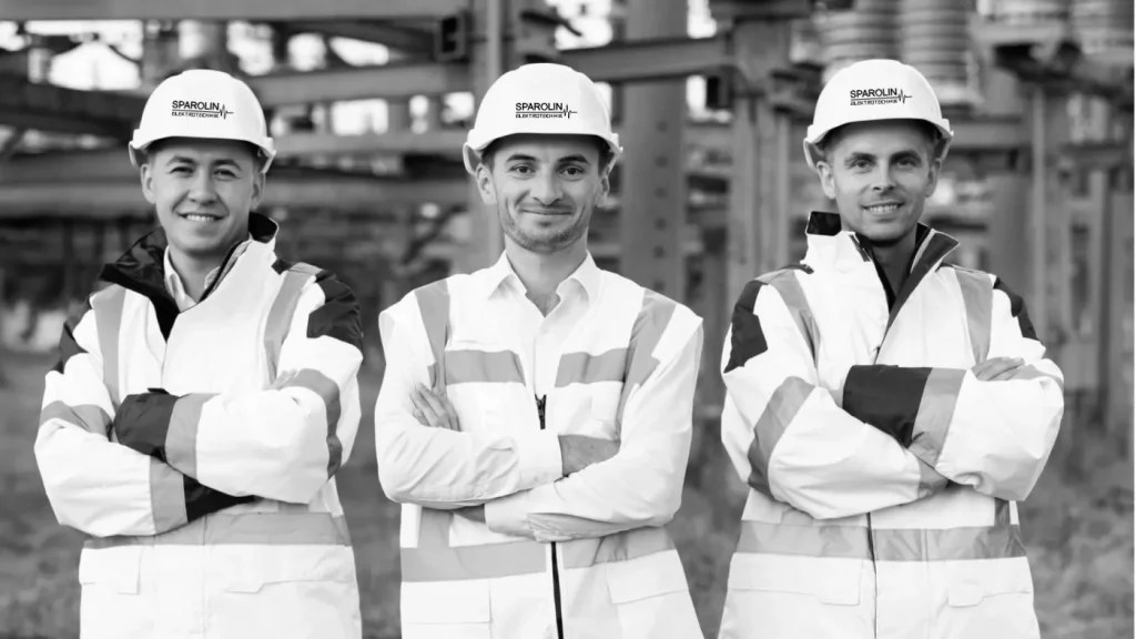 3 Techniker stehen vor einer Industrieanlage