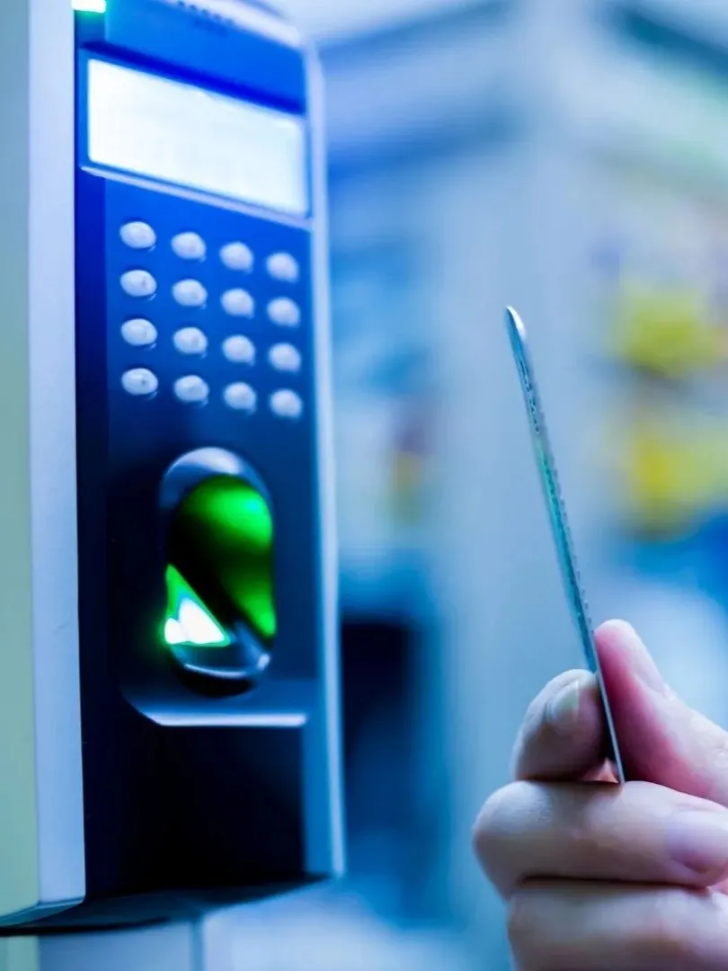 Eine Hand hält eine Chipkarte vor das Bedienteil des Zugangskontrollsystems.