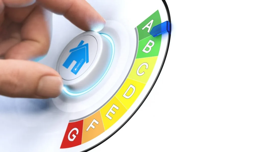 Ein Drehknopf mit darauf abgebildetem Haus mit den Wahlmöglichkeiten der Energieklassen-Anzeige vor weißem Hintergrund